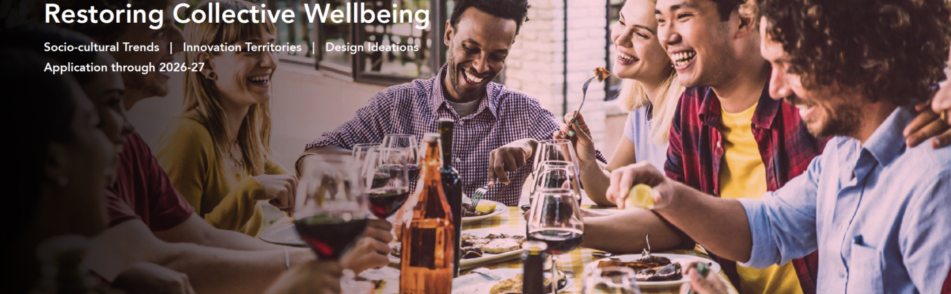 Title page of the January 2025 trend report, Restoring Collective Wellbeing. The image shows a group of 30-something adults sharing a meal around a table