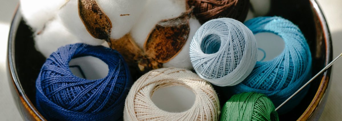 Cotton balls and cotton yarn in a bowl.