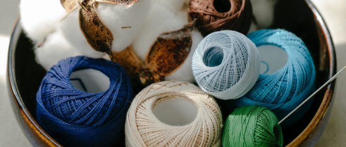 Cotton balls and cotton yarn in a bowl.