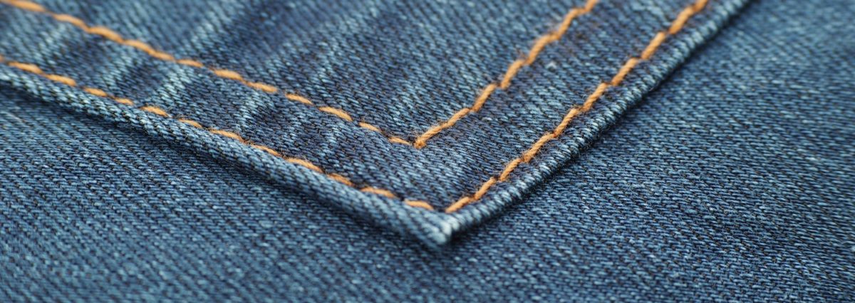 Close up of stitching on jean pockets.