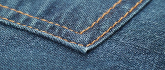 Close up of stitching on jean pockets.