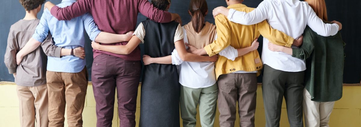 A group standing in front of a chalkboard ready to solve a problem together.