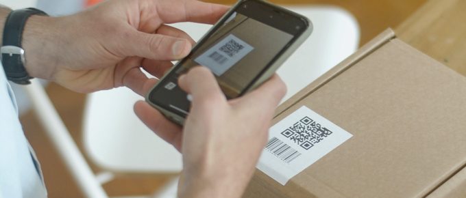 Holding a phone and scanning the QR code on smart packaging